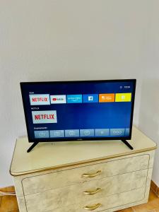 telewizor z płaskim ekranem siedzący na komodzie w obiekcie Knuffige Ferienwohnung im Herzen von Haiger w mieście Haiger