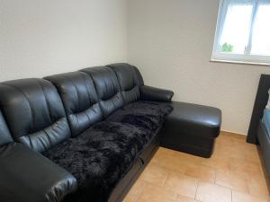 a black leather couch in a living room at Knuffige Ferienwohnung im Herzen von Haiger in Haiger