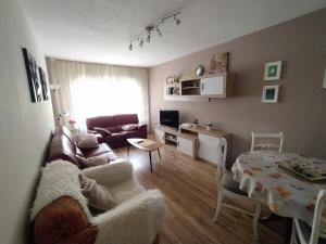 uma sala de estar com um sofá e uma mesa em Apartamento Centro y Playa em Gijón
