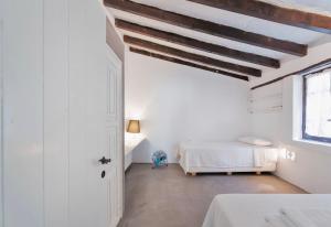 a white bedroom with a bed and a window at Villa Nefeli in Sani Beach