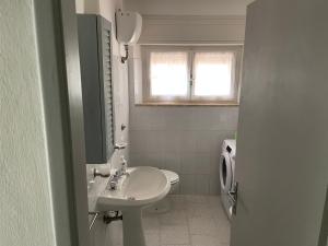 La salle de bains blanche est pourvue d'un lavabo et de toilettes. dans l'établissement Giardino Sud - a pochi passi dal mare, à San Vincenzo