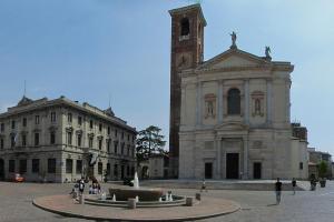 ein Gebäude mit einem Uhrturm mit einem Brunnen davor in der Unterkunft Bilocale in Centro - 10km da Malpensa in Gallarate