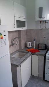 una pequeña cocina con fregadero y microondas en departamento en almagro, 2 huéspedes en Buenos Aires