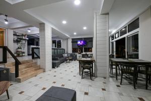 un soggiorno con tavoli, sedie e un divano di MELODİ BUTİK OTEL a Edremit