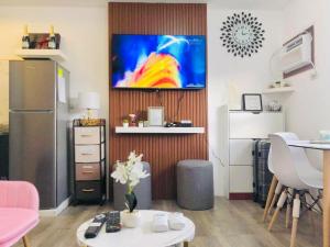 a living room with a television on a wall at Spacious Combine Family Unit Condo at Mesaverte Residences downtown near SM Gaisano Robinson and Centrio in Cagayan de Oro