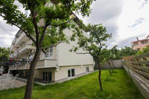 una casa con un cortile alberato di fronte di MELODİ BUTİK OTEL a Edremit