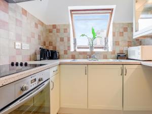 d'une cuisine avec des placards blancs, un évier et une fenêtre. dans l'établissement Prideaux-3537, à Eastbourne