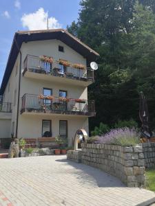 - un grand bâtiment avec balcon et fleurs dans l'établissement Penzion U Klujů, à Věstín