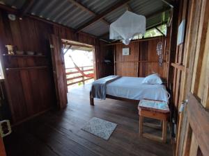 1 dormitorio con 1 cama en una casa de madera en Cabaña Casa Cielo, en El Valle
