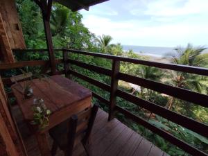 terraza de madera con mesa y vistas al océano en Cabaña Casa Cielo, en El Valle