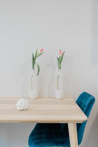 a wooden table with vases and a blue chair at ESTEA Quality Living in Volos