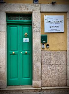 una puerta verde al lado de un edificio en La Maison, en Manfredonia