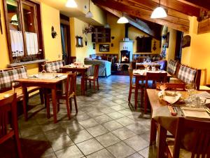 un ristorante con tavoli e sedie in legno e un camino di Hostellerie Le Lievre Amoureux a Valpelline