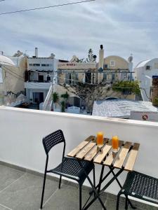 a wooden table and two chairs on a balcony at Villa Markos in Perissa