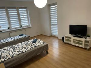 a living room with two beds and a flat screen tv at Pokoje KEN in Warsaw