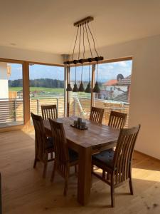 a dining room with a wooden table and chairs at Ferienwohnung Schmied von Almertsham in Höslwang