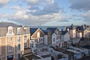 a group of houses in a city with the ocean in the background at Ker Romain - Sea View - 3 bedrooms Appt in Saint Malo