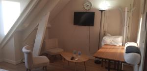 una pequeña sala de estar con mesa y TV. en BELEM, en Romorantin-Lanthenay