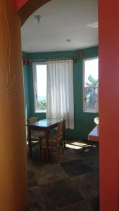 a dining room with a table and two windows at El Tucan in Puerto Escondido