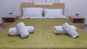 a bed with two towels and two pillows on it at Cozy ground floor house in Agia Triada