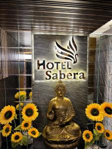 a gold buddha statue in front of a hotel saoria sign at Hotel Sabera in Siliguri