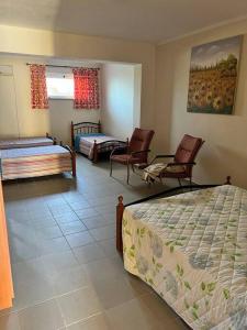 - une chambre avec 2 lits et 2 chaises dans l'établissement Casa vicino al mare, à Bianco