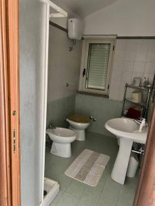 La salle de bains est pourvue de 2 lavabos et de 2 toilettes. dans l'établissement Casa vicino al mare, à Bianco