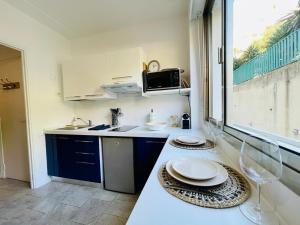 una cucina con un bancone con due piastre e una finestra di Studio au bord de mer 1 a Mentone