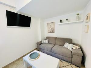 un soggiorno con un divano e una TV di Studio au bord de mer 1 a Mentone