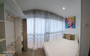 um quarto com uma cama branca e uma janela em Beau studio / Clim / Parking / Plage à 200 m em San-Martino-di-Lota