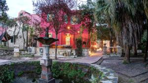 a bird bath in front of a pink house at Heron's Path II in Análipsis