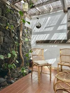 a patio with two chairs and a stone wall at Casa mar y jardín: tranquilidad y vistas únicas in Los Cancajos