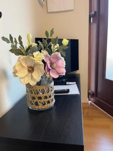 un vase de fleurs assis sur une table dans l'établissement Casa Mimosa, à Cannobio