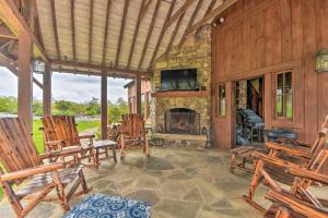 a porch with rocking chairs and a stone fireplace at Cottage with Screened Porch and Trails Near Cashiers! in Glenville