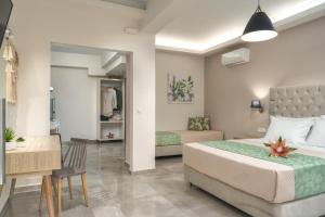 a bedroom with a bed and a table and a desk at Rania's Deluxe Studios in Tsilivi