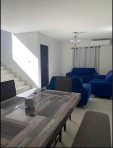 ein Wohnzimmer mit einem Tisch und blauen Stühlen in der Unterkunft Casas Residenciales Ciudad Obregón in Ciudad Obregón