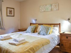 a bedroom with a large bed with towels on it at Riverbank Cottage-uk42229 in Low Borrowbridge