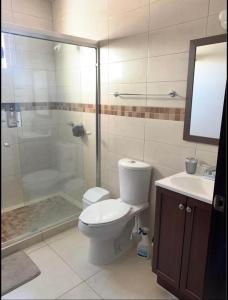 a bathroom with a toilet and a shower and a sink at Casas Residenciales Ciudad Obregón in Ciudad Obregón