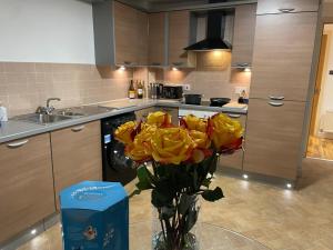 een vaas gevuld met gele rozen in een keuken bij Edinburgh Apartment BR in Edinburgh