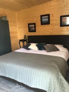 a bedroom with a large bed in a room with wooden walls at Hoeve Delshorst in Heibloem