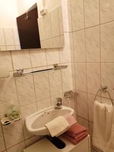 W łazience znajduje się umywalka, lustro i ręczniki. w obiekcie Rooms Marica w mieście Sveti Juraj