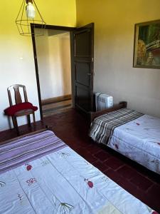 ein Hotelzimmer mit 2 Betten und einem Stuhl in der Unterkunft Alquilo casa quinta in Pocito