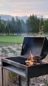 una parrilla con fuego en un campo en MODERNAS CABAÑAS EN USPALLATA en Uspallata