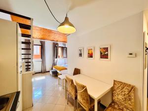 uma cozinha e sala de jantar com mesa e cadeiras em Falcone 22 em Bolonha