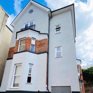 a white building with a balcony on top of it at Large, newly renovated, three bedroom TOWN CENTRE split level apartment with free parking, sleeps seven - Walking distance to beach in Bournemouth