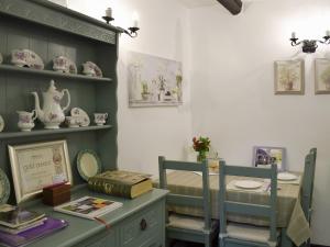 a room with two chairs and a table with china at Ivy Cottage in Henllan