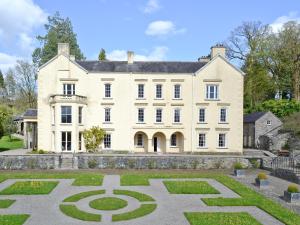 a large white house with a garden in front of it at Ivy Cottage in Henllan