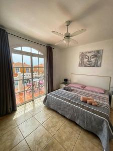 a bedroom with a large bed and a balcony at Villa Katerina in Caleta De Fuste