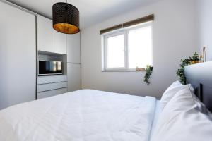 - une chambre blanche avec un lit et une fenêtre dans l'établissement Sweet Escape- 1BR in Pipera, à Voluntari