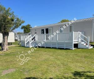 a mobile home with a large porch and white railing at Spacious 3 bed @ Seal Bay Resort (Bunn Leisure) in Selsey